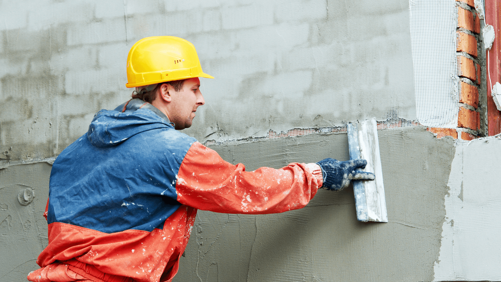 Solid plasterer applying render to an exterior wall