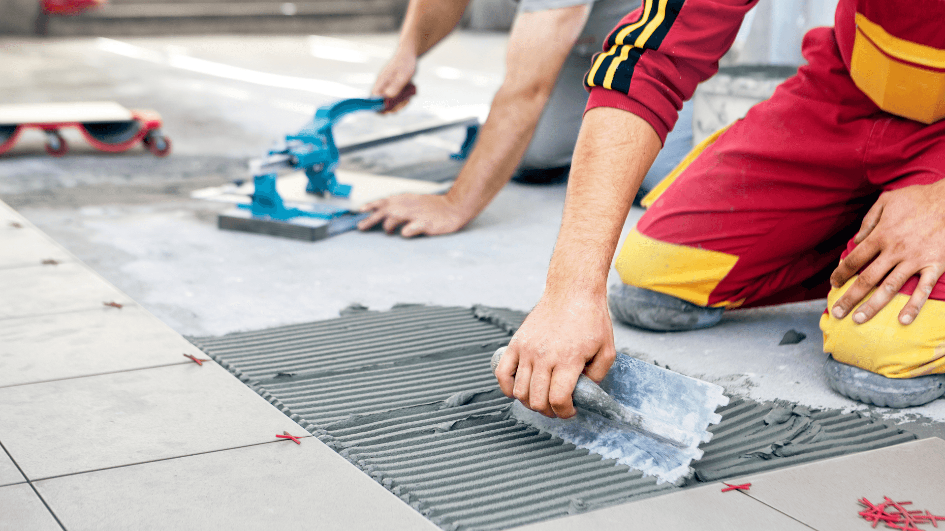Tiler installing floor tiles on a residential build